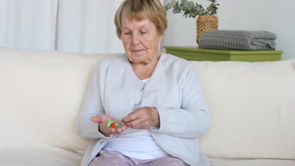 Age, Medicine, Healthcare And People Concept - Senior Woman With Pills At Home.