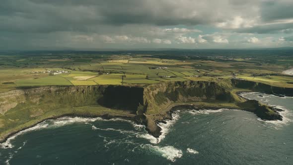 Cliff Ocean Ireland Shore Aerial View: Green Grassy Valley with Little Farms in Irish Countryside