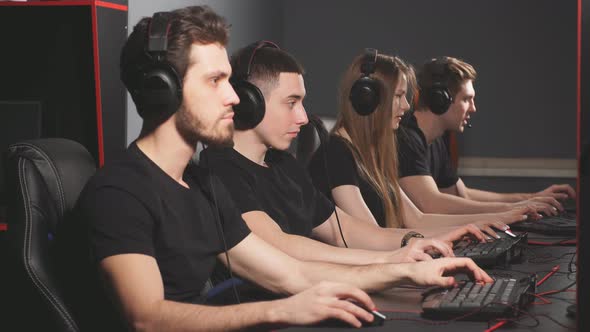 Group of Concentrated People in Headphones Enjoying Online Video Game on Computers of Gaming Centre