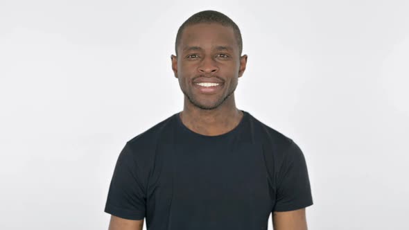 Young African Man Smiling at Camera on White Background