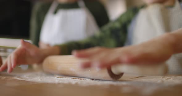 Mother and Little Son Making Handmade Cookies at Home Rolling Raw Dough Together at Kitchen