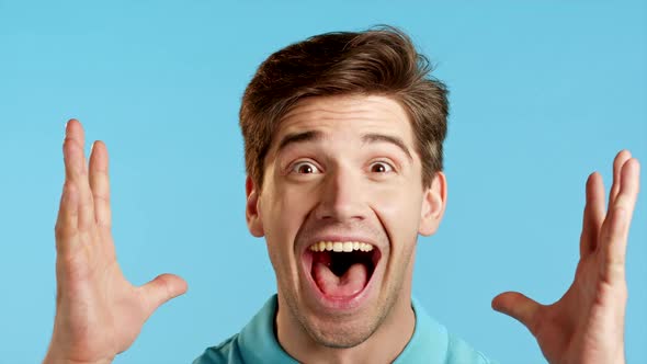 Close-up Face of Amazed European Man Shocked, Saying WOW. Handsome Guy Surprised To Camera Over Blue