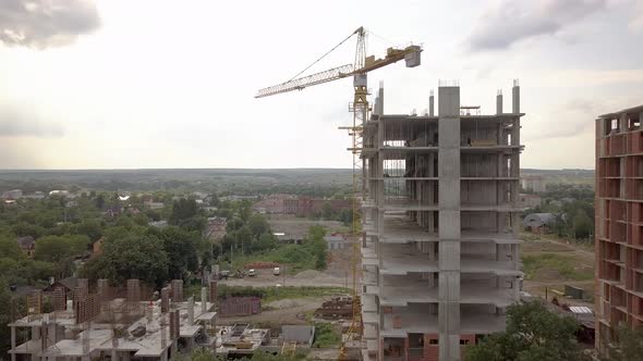 Aerial view of tower crane and residential building under construction.