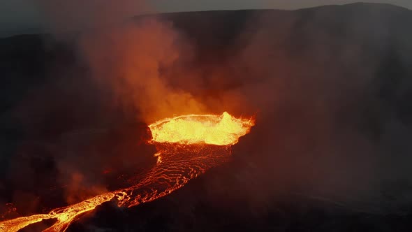 Closeup of Boiling Magma in Crater of Active Volcano and Lava Stream Flowing Down