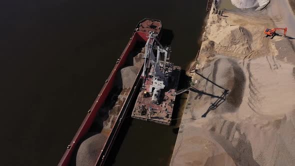 A Harbor Crane Unloads a Sand Barge
