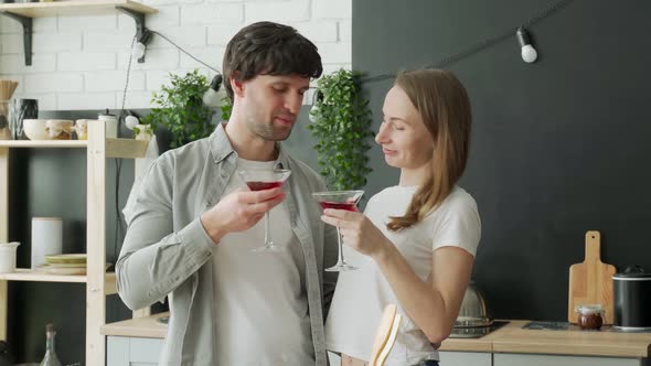 Young Married Couple Drinks Cocktails in the Kitchen at Home
