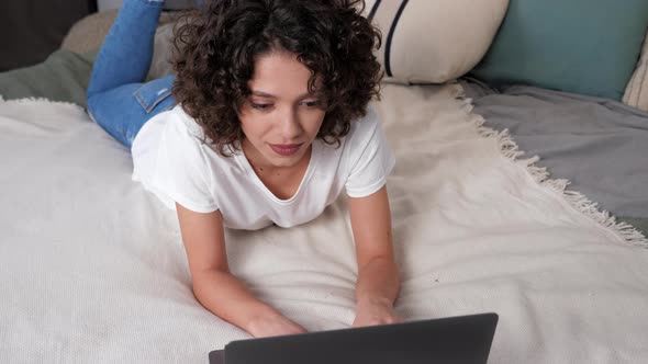 Smiling Hispanic Curly Woman Student Study Uses Laptop Distance Education