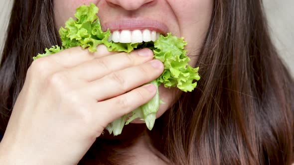 pretty happy woman girl putting salad leaf lettuce in mouth.  healthy food, nutrition concept, weigh