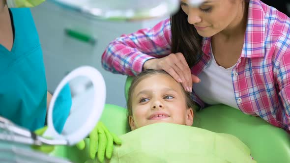 Adorable Child Smiling After Dental Procedures, Watching Healthy Teeth in Mirror