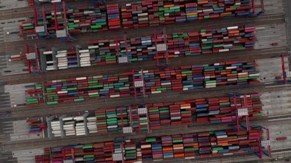 Ascending Aerial Overhead View of Automated Cranes Moving Large Shipping Cargo Containers in Hamburg
