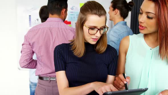 Business executives discussing over digital tablet