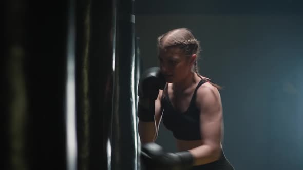 Athletic Female Fighter Trains His Punches Beats a Punching Bag Kickboxing Training Day in the