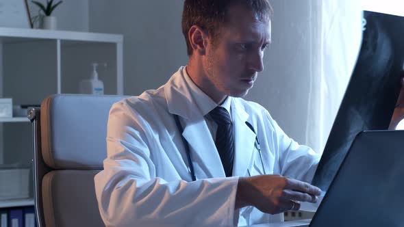 Professional medical doctor working in hospital office using computer technology.