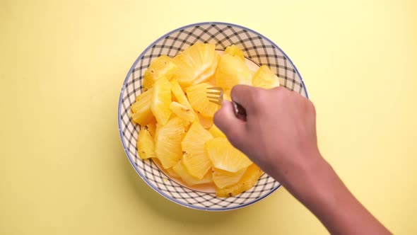 Slice of Pineapple in Bowl on Yellow Background