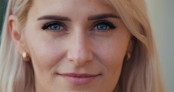 Close-up Face of a Beautiful Blonde with Blue Eyes in Slow Motion