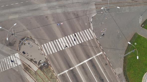 Cars and Pedestrians Move Through Crosswalk Near Intersection in the City  Drone Overhead Shot