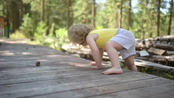 Little Funny Cute Blonde Girl Child Toddler in Yellow Undershirt and Grey Shorts Walking Playing on