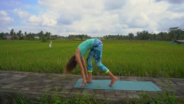 Slowmotion Shot of a Young Woman Practicing Yoga on a Beautiful Rice Field