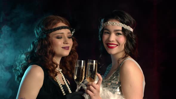 Beautiful Flappers Women Dressed in Style of Roaring Twenties Drinking Champagne. Vintage, Retro