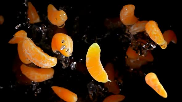 Slices of Mandarins with Water Flies To the Camera