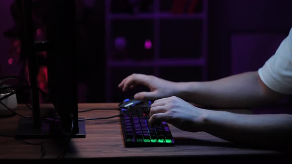 Gamer Typing on Backlight Keyboard Closeup Man Playing Video Game