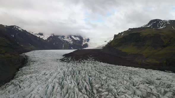 Iceland glacier with mountains and clouds with drone video moving forward wide shot.