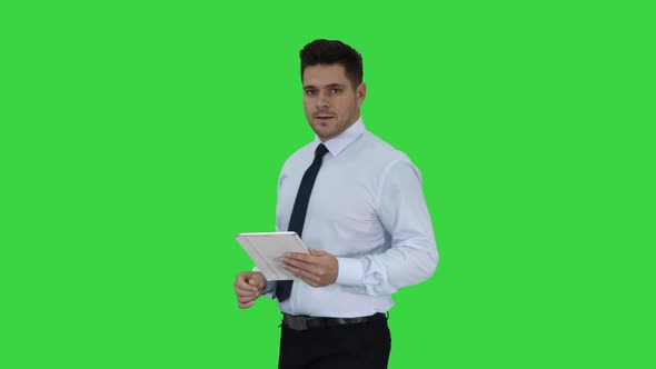 Happy Businessman Walking in Using Tablet Turning on Something or Opening Something on a Green