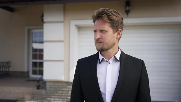 Confident Elegant Caucasian Man Standing on Sunny Front Yard Looking Around