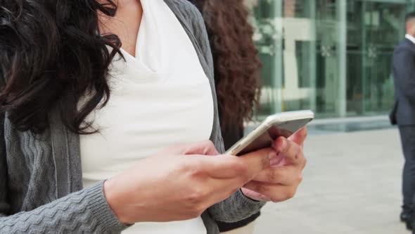 Businesswoman text messaging on mobile phone