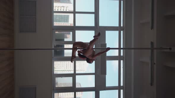 Athletic Woman Pole Dancer Performs Spectacular Tricks on Pole