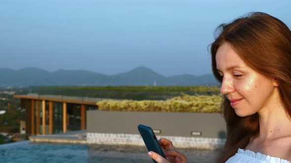 Happy Travel Woman with Smartphone Standing on Luxury Hotel Rooftop