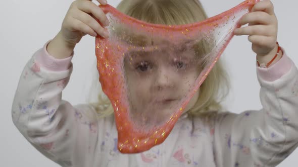 Kid Playing with Hand Made Toy Slime. Child Having Fun Making Red Slime