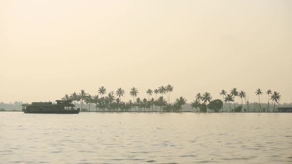 Landscape view of a houseboat floating on a river, Kerala Backwaters, India