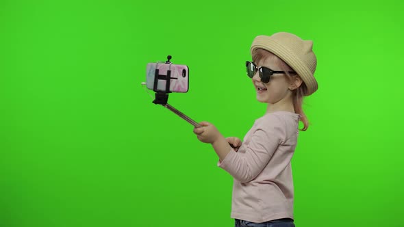 Girl Child Makes Selfie, Blogging on Mobile Phone Using Selfie Stick. Chroma Key