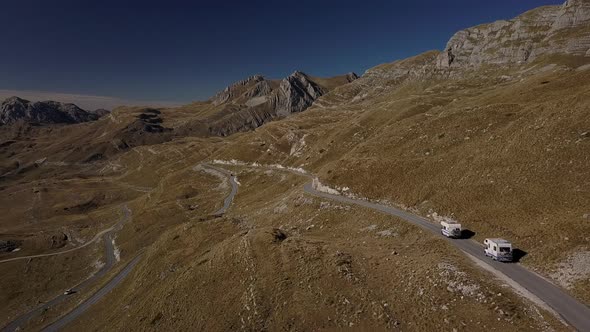 Two Motorhome Cars Driving Slowly on Serpentine Road in High Mountains Rbbro