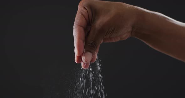 Video of cook throwing salt on the table on black background