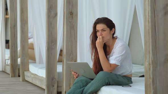 Serious Young Woman With Laptop Thinking About Something