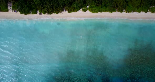 Tropical above abstract shot of a white sandy paradise beach and aqua blue water background in 4K