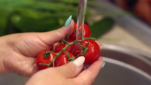 Close-up of a Woman Washing Cherry Tomatoes Under Water in the Kitchen Sink