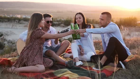 Cheerful People Cheering with Beer and Smiling While Sitting at a Summer Picnic