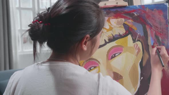 Asian Artist Girl In Wheelchair Holding Paintbrush Mixed Colour And Painting A Girl On The Canvas