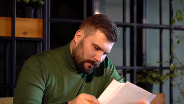 Businessman Writing Document in Cafe.