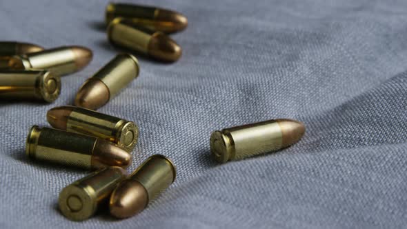 Cinematic rotating shot of bullets on a fabric surface - BULLETS 084