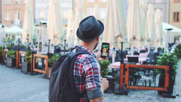 Back View of Man Making Video Call on Smartphone with Female Tourist From Other Place