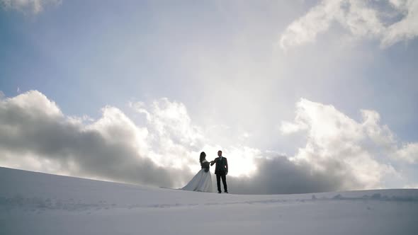 Newlyweds. Lovely Young Groom and Bride Stay Together on Top of the Mountain, Winter, Mountains