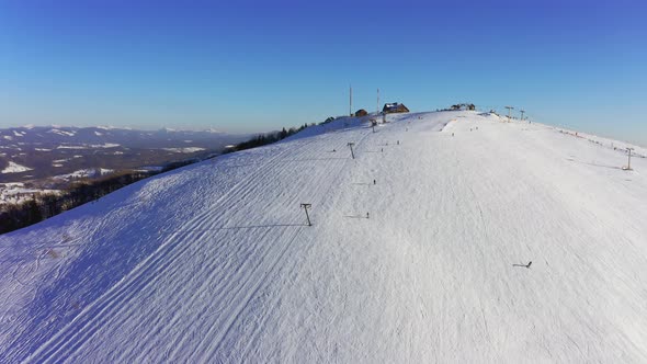 Old Ski Station on a Snowy Mountain Slope with a Lot of People on Skis and Snowboards