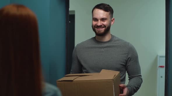 Smiling Courier Man Delivering Parcel To Woman Client on Doorstep at Apartment Slow Motion