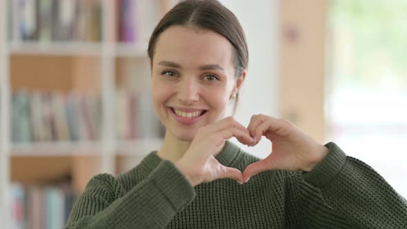 Heart Sign with Hand By Young Woman in Love