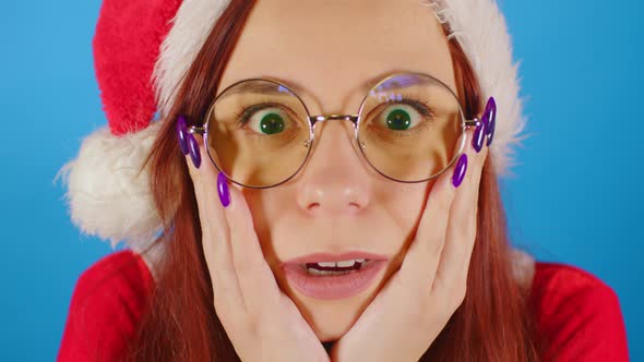 Woman in santa costume opens her mouth in surprise