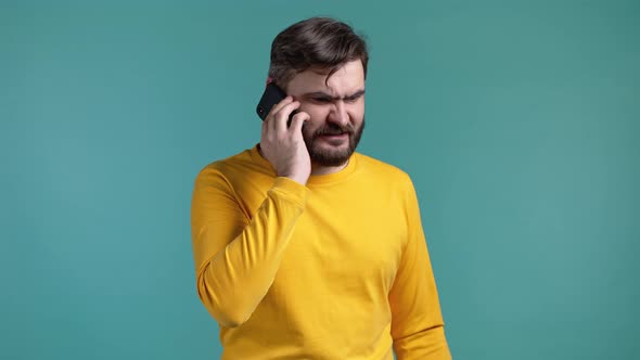 Angry Bearded Man in Yellow Tshirt Screaming Down His Mobile Phone